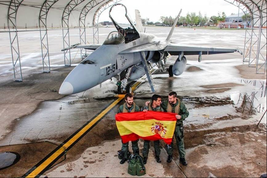 Tres de los pilotos del Ala 12 posan, antes de despegar, con la bandera de Espa