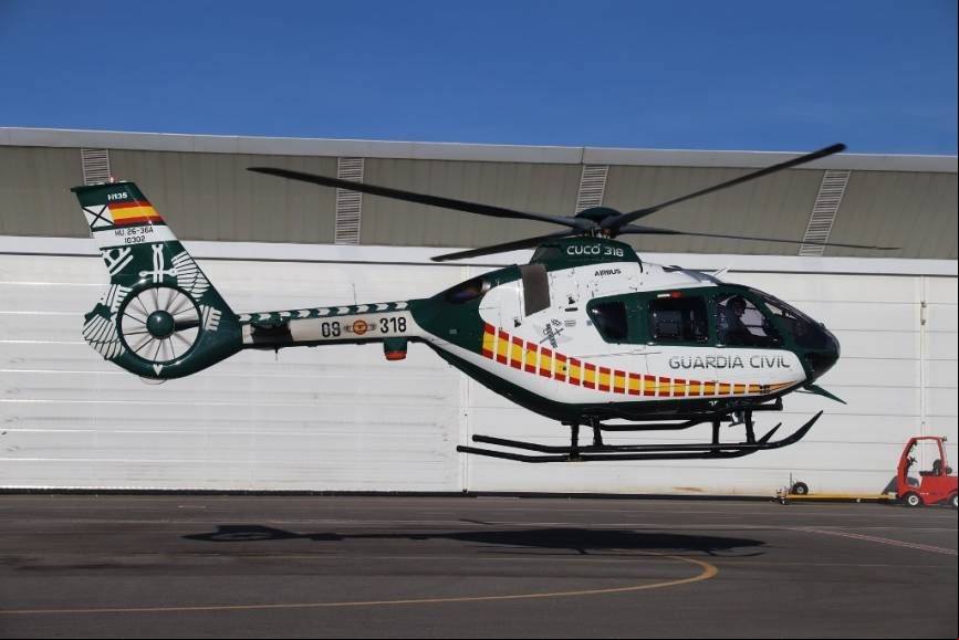Uno de los nuevos H135 hace un vuelo estacionario frente al gran hangar del base del SAER de Torrej